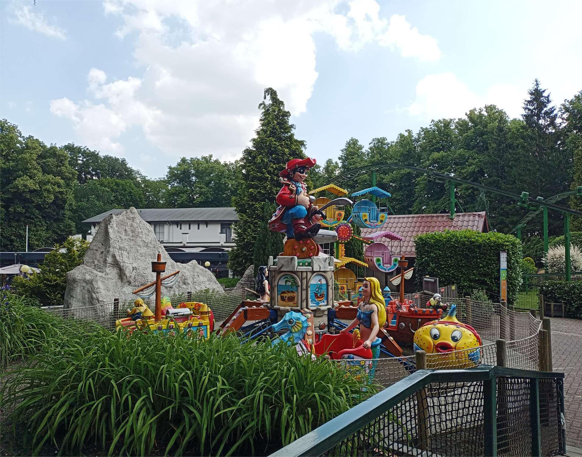 Op de foto staan twee attracties voor de jongste kinderen. Op de voorgrond een piraten draaimolen waarvan de bakjes omhoog kunnen. Daarachter een mini-reuzenrad en er is nog een glimp te zien van de keverachtbaan.