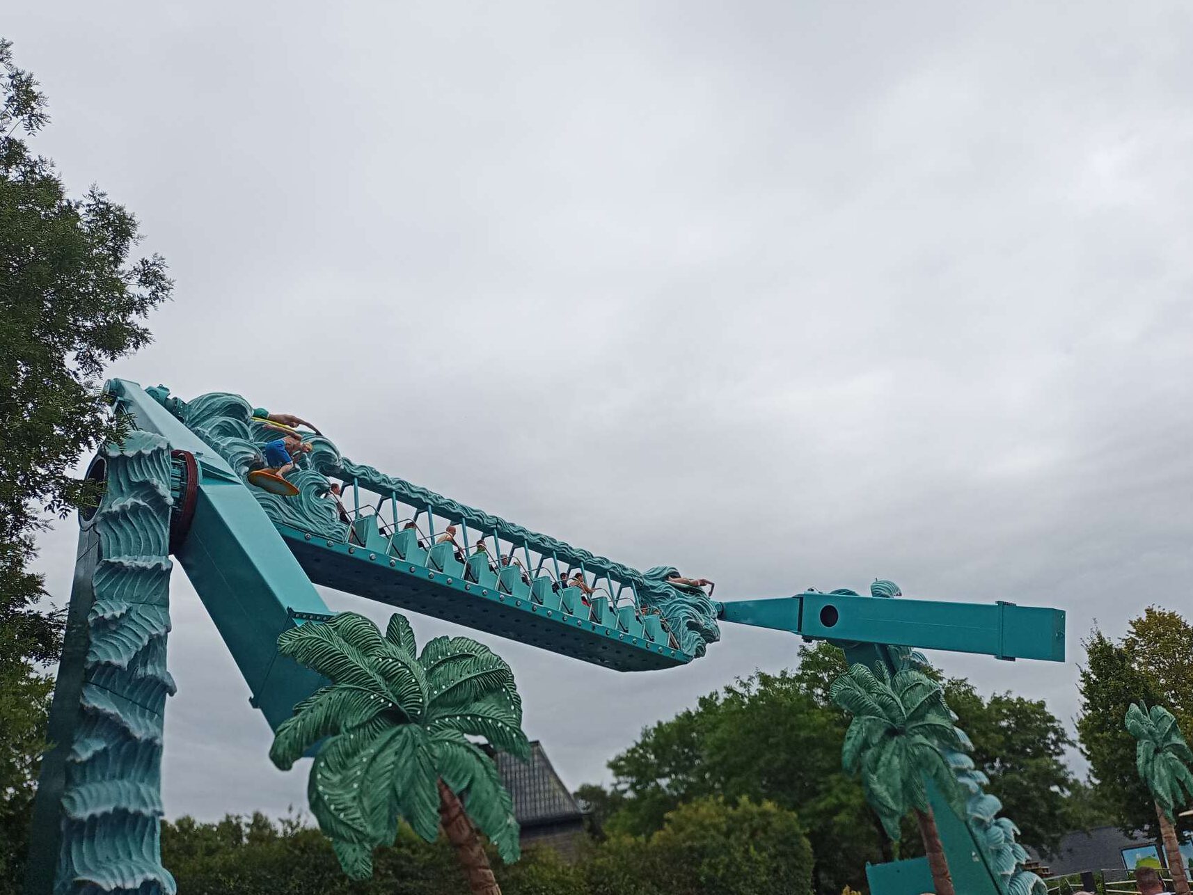 Het is een blauw apparaat met 2 armen. Tussen de twee armen is een constructie met bankjes die naar rechts wijzen. De armen zijn onafhankelijk van elkaar in de beweging.